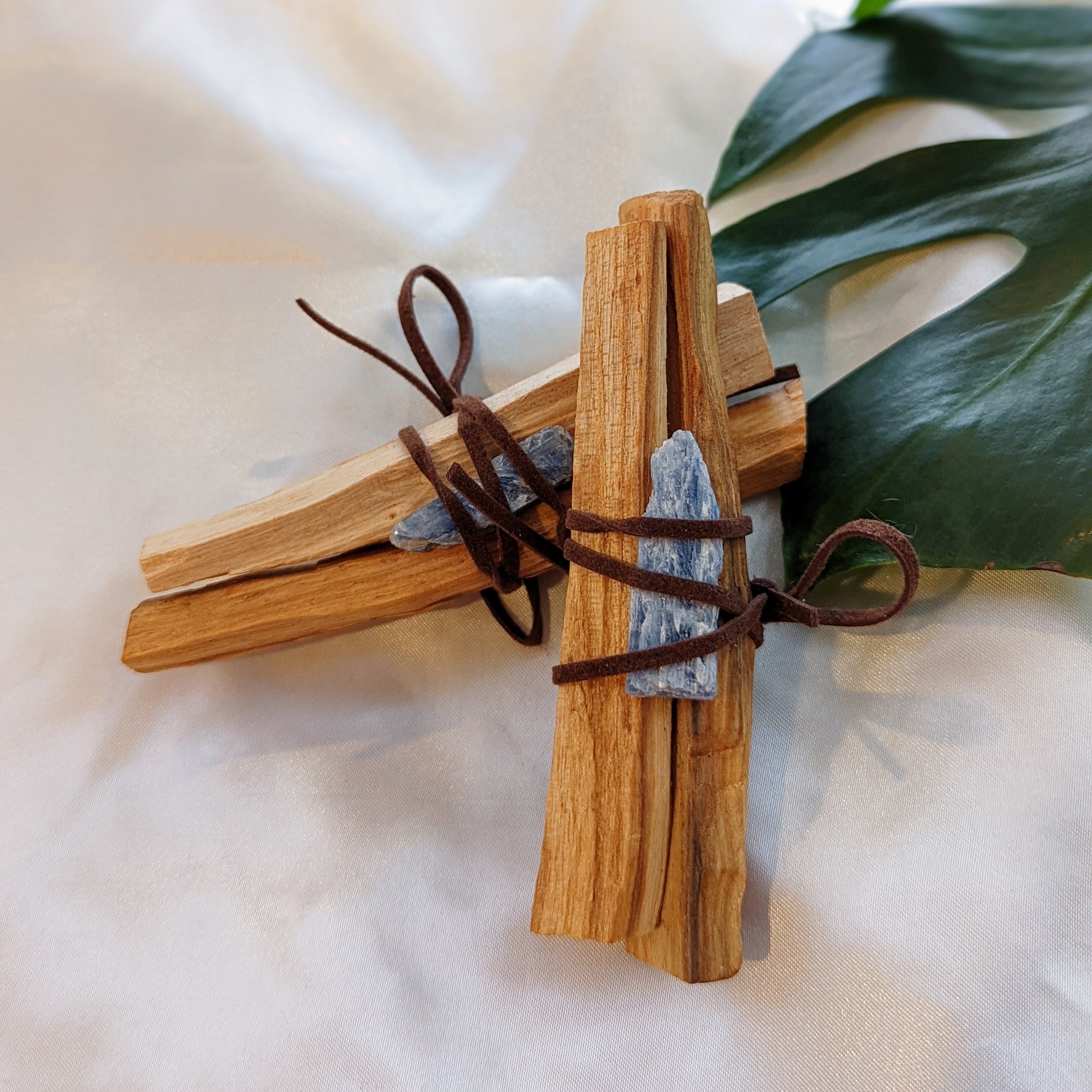 Wooden palo santo incense sticks with a leaf on a light background